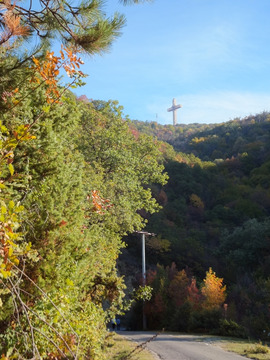 Millenium Cross zdobiący szczyt wzgórza Vodno w Skopje i październikowe słońce.