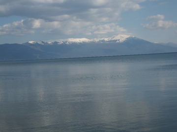 Przy odpowiednim nasłonecznieniu na przeciwległym brzegu jeziora można dostrzec górskie szczyty Albanii.